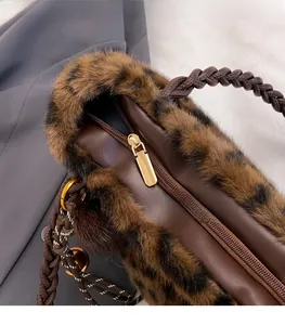 Detail of leopard faux fur tote with gold zipper hardware and braided brown handle