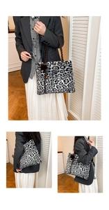 Detail showing plush leopard print tote bag with woven leather handles and fur pompom