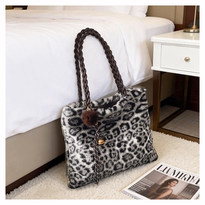 Détail du sac cabas en fausse fourrure léopard avec poignée tressée et pompon doux
