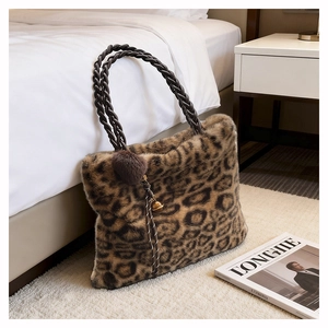 Détail d'un sac en peluche léopard avec poignées tressées et breloque pompon