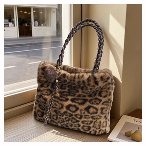 Vue détaillée du sac cabas en peluche léopard avec anses tressées et pompon décoratif