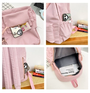 Detail view of pink corduroy backpack featuring multiple storage pockets and anti-theft design