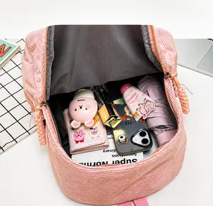Detail of light pink corduroy backpack interior showing large capacity for essentials