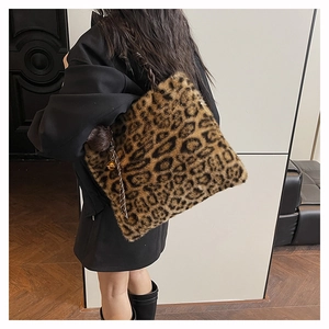Close-up of leopard print plush tote bag with woven handles and a metal bell charm
