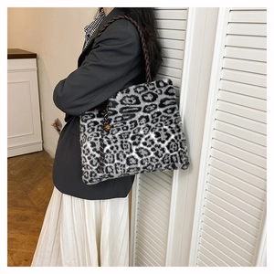 Detail of plush leopard print tote bag with woven strap and metallic ornament