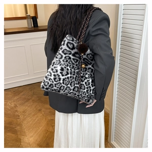 Detail of plush leopard print tote bag with braided handle and fuzzy pompom charm