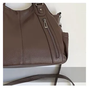 Close-up of premium dark brown lychee pattern leather and vertical zipper on tote bag