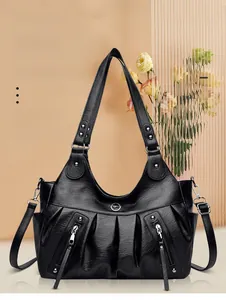 Close-up of black PU leather tote bag with pleated texture and silver metal zippers