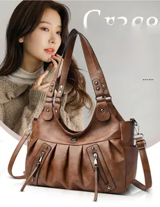 Close-up of brown hobo bag showing pleated leather texture and metallic kangaroo logo