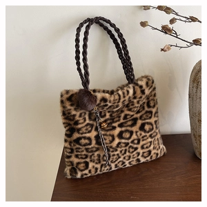 Detail of leopard print faux fur tote bag with braided handles and pompom charm