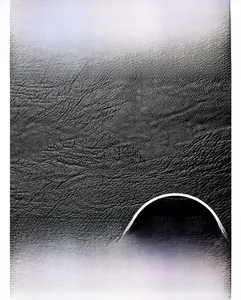 Close-up of black lychee grain leather texture with a metallic kangaroo logo detail