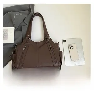 Detail of vintage brown lychee grain leather tote with side pockets and zippers