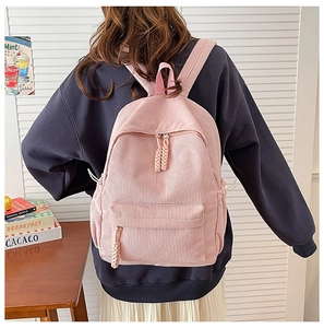 Detail of pink corduroy backpack with dual zipper closure and soft textured fabric