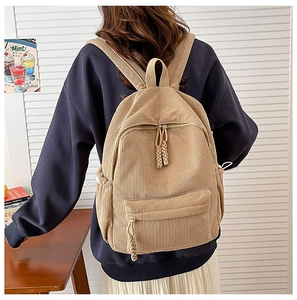 Detailed texture of corduroy fabric on a beige backpack with adjustable drawstrings