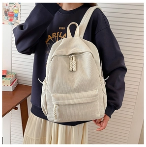 Detail of cream corduroy backpack with vertical texture and woven zipper pullers