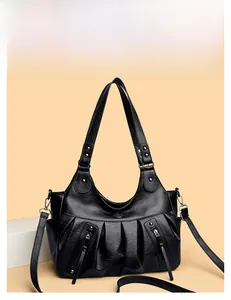 Close-up of black pleated faux leather hobo bag with side zippers and soft lychee texture