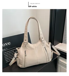 Detail of off-white faux leather tote bag with lychee texture and dual zipper pockets