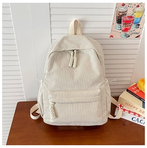 Detailed close-up of beige corduroy backpack with woven zipper and side drawstring pocket