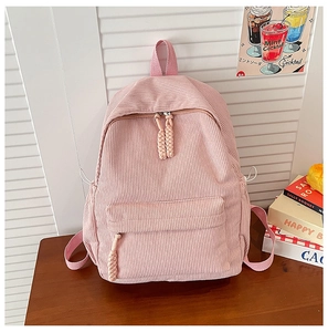 Detail of pink corduroy backpack with drawstring side pockets and braided zipper pulls
