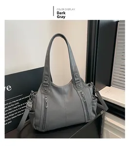 Detail of dark gray tote bag featuring litchi texture and dual vertical metal zippers