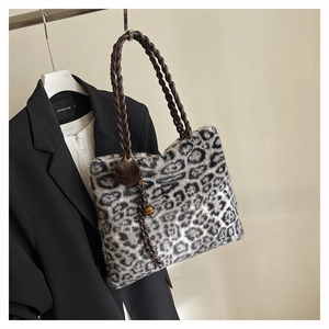 Détail du sac cabas en peluche léopard avec bandoulière tressée et pompon décoratif