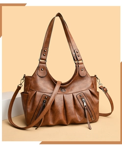 Detail of caramel lychee grain leather handbag featuring pleated design and silver rivets
