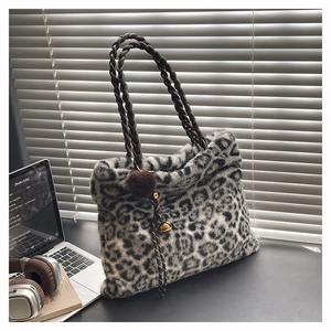 Détail du sac cabas en fausse fourrure léopard avec anses tressées et breloque pompon doux