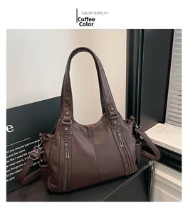 Detail of dark brown leather tote bag with lychee texture and dual front zipper pockets