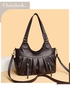Detail of vintage pleated dark brown tote bag with dual zippers and logo on beige background