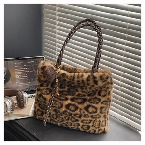 Détails d'un cabas en peluche léopard avec poignées tressées et breloque décorative chic