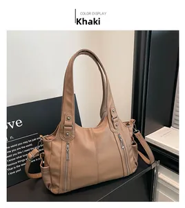 Detailed macro view of khaki faux leather texture and decorative zippers on tote bag