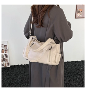 Detail of off-white tote bag featuring premium lychee texture and dual vertical zipper pockets