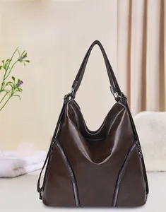 Detail view of dark brown faux leather shoulder bag with decorative front zipper