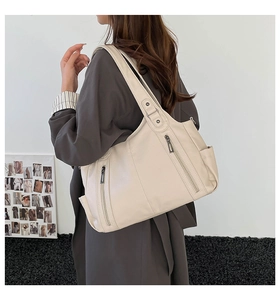 Side view of cream white tote bag with lychee texture and dual vertical zipper details