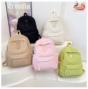 Detailed view of corduroy backpacks in five colors with woven rope zipper pulls