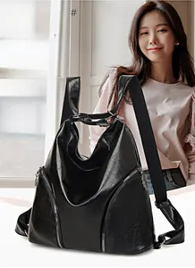 Detail view of the black soft leather backpack featuring decorative metal zippers