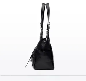 Detail view of black leather tote bag featuring side pockets and silver D-ring hardware