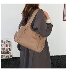 Close-up of brown vintage tote bag featuring vertical zippers and soft leather texture