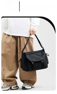 Close-up of black waterproof messenger bag with dual buckle closure and adjustable strap