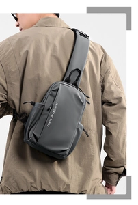 Sac bandoulière gris étanche pour homme avec finition mate, porté sur l'épaule en extérieur