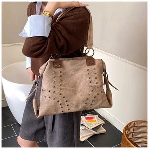 Detail of khaki retro faux leather tote bag featuring metallic rivet geometric patterns