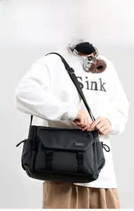 Model wearing a black water-resistant techwear messenger bag with adjustable strap