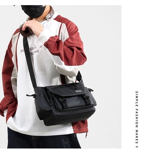Detail of waterproof matte black messenger bag with FASHION label and adjustable strap