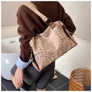 Detailed view of khaki vintage tote bag with metal rivets and wide shoulder strap