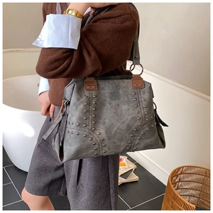 Detail of vintage grey tote bag featuring metal rivets and premium suede texture