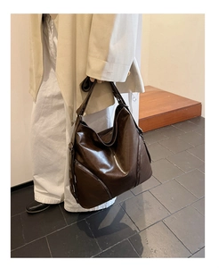 Detail of vintage brown leather tote bag with silver side zippers in casual style