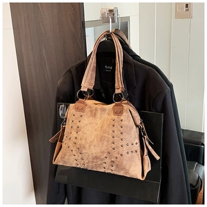 Detailed view of the vintage brown tote bag with metal rivets and double top handles