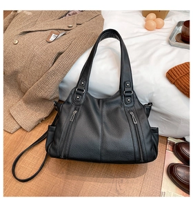 Detailed view of black lychee grain leather tote bag with silver zippers and hardware
