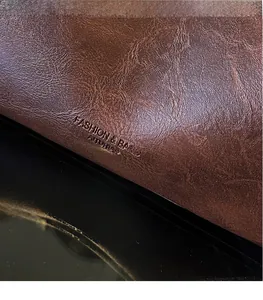 Macro shot of brown retro lychee grain leather tote with embossed logo details