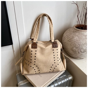 Detail view of khaki canvas tote with bronze rivet studs and sturdy double handles